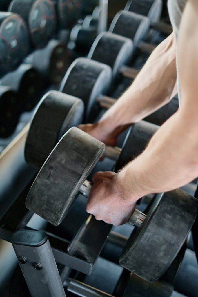 Person Taking Dumbbells from a Rack